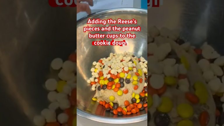 Adding the Reese’s pieces and peanut butter cups.  #baking #dessert #bakingrecipes #reeses #shorts