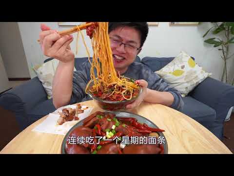 A plate of spicy and flavorful braised pork knuckle, paired with a bowl of spicy hand pulled noodles